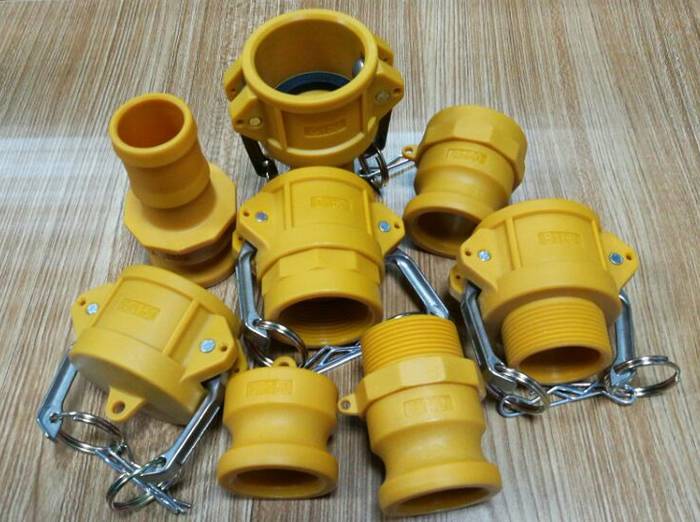 There are many yellow nylon camlock couplings on the desk.